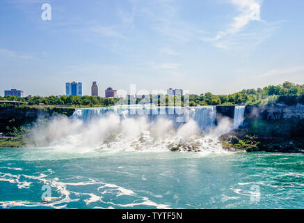 Cascate del Niagara, Canada - 27 agosto 2017: le Cascate Americane e nelle vicinanze di edifici sono visibili attraverso il Fiume Niagara. Foto Stock