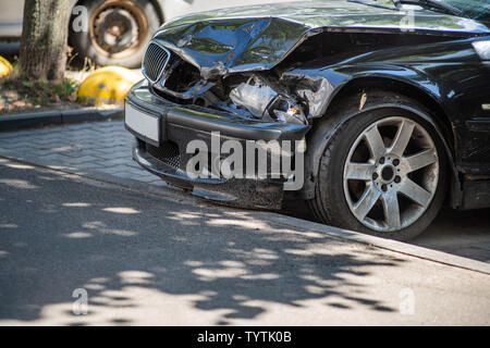 La parte anteriore di un auto nera ha avuto un incidente sulla strada. Collisione frontale Foto Stock