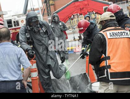 Membri del New York ai Vigili del Fuoco di materiali pericolosi Team effettuano le procedure di decontaminazione NEGLI STATI UNITI. Soldati da Ft. Il tamburo 59a società CBRN a seguito di una formazione congiunta evolution in New York City nov. 29, 2016. Questo evento di formazione era parte di una settimana di formazione della durata di esercizio organizzato dalla città di New York e DEGLI STATI UNITI Esercito a nord, e supervisionato da U.S. Comando Nord. Gli eventi dà i soldati locali e primi responder l esperienza del lavoro insieme durante un complesso chimici, biologici, radiologici o nucleari emergenza. Foto Stock