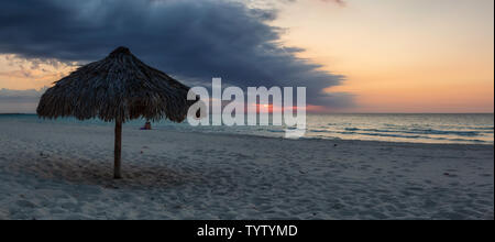 Bella vista panoramica della spiaggia di sabbia durante una drammatica NUVOLOSO TRAMONTO. Prese a Varadero, Cuba. Foto Stock