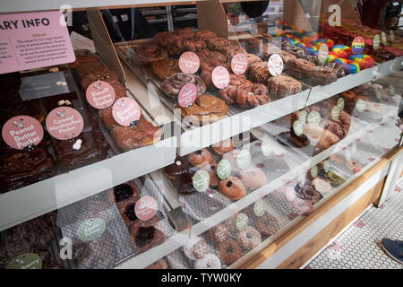 Selezione di specialità ciambelle sul display di stans ciambelle e caffè caffè shop di Damen in wicker park Chicago IL USA Foto Stock