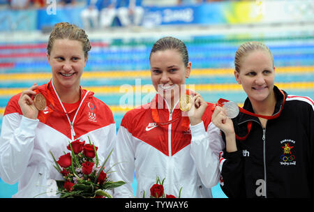 USA la medaglia d'oro Natalie Coughlin (C) mostra la sua medaglia lungo la medaglia di argento dello Zimbabwe Kirsty Coventry (R) e medaglia di bronzo USA Hoelzer Margaret(L) dopo la cerimonia di premiazione per le Donne 100m Backstroke presso il National Aquatics Centre Giochi Olimpici Estivi a Pechino il 12 agosto 2008. Coughlin il momento era 58.96. (UPI foto/Pat Benic) Foto Stock