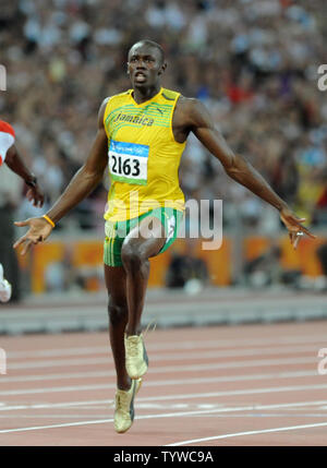 La Giamaica Usain Bolt (R) attraversa la linea del traguardo in giubilo per vincere la medaglia d'oro negli uomini 100 metri di gara presso lo Stadio Nazionale Giochi Olimpici Estivi a Pechino il 16 agosto 2008. La vite ha stabilito un nuovo record mondiale di 9,69 secondi. (UPI foto/Pat Benic) Foto Stock