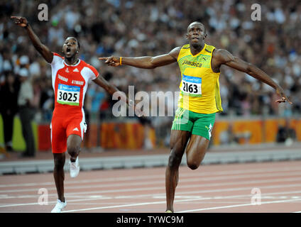 La Giamaica Usain Bolt (R) attraversa la linea del traguardo per vincere la medaglia d'oro negli uomini 100 metri di gara presso lo Stadio Nazionale Giochi Olimpici Estivi a Pechino il 16 agosto 2008. La vite ha stabilito un nuovo record mondiale di 9,69 secondi. A sinistra è la Trinidad di Richard Thomas che hanno terminato al secondo. (UPI foto/Pat Benic) Foto Stock