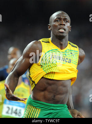 La Giamaica Usain Bolt (R) attraversa la linea del traguardo in giubilo per vincere la medaglia d'oro negli uomini 100 metri di gara presso lo Stadio Nazionale Giochi Olimpici Estivi a Pechino il 16 agosto 2008. La vite ha stabilito un nuovo record mondiale di 9,69 secondi. (UPI foto/Pat Benic) Foto Stock