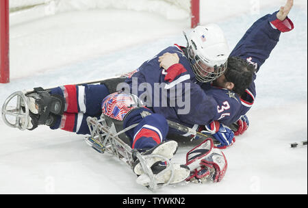 Il Team USA il Brad Emmerson abbracci goalie Steve Cash #34 come si celebra in oro vincente contro la squadra in Giappone la medaglia d'oro sledge hockey durante il Vancouver 2010 Paralimpiadi Invernali a UBC Thunderbird Arena di Vancouver, British Columbia, 20 marzo 2010. Il Team USA ha vinto 2-0 con il Giappone prendendo argento. UPI/Heinz Ruckemann Foto Stock