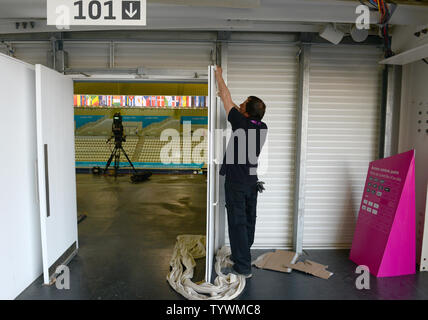 Un lavoratore mette tocchi di rifinitura su porte a Aquatics Centre nel Parco Olimpico di Londra del luglio 24, 2012. Tre giorni rimangono fino a cerimonie di apertura per le Olimpiadi del 2012. UPI/Terry Schmitt Foto Stock