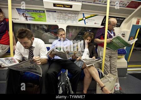 Pendolari sulla Jubilee Line della metropolitana leggere quotidiani sulla corsa di distanza dal parco olimpico di Londra il 25 luglio 2012. I quotidiani sono disponibili gratuitamente la mattina e la sera nella maggior parte delle stazioni. UPI/Terry Schmitt Foto Stock