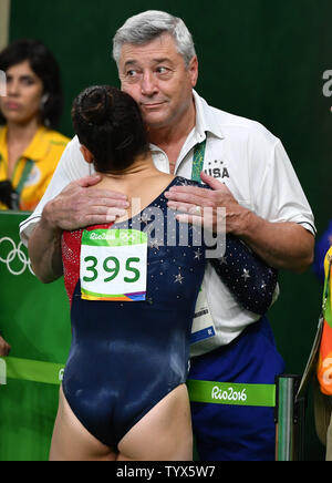 Ginnasta americano Aly Raisman si consola con pulmann Mihai Brestyan dopo quasi cadere il raggio nel fascio di equilibrio delle qualifiche al Rio 2016 Olimpiadi di estate a Rio de Janeiro, Brasile, 6 agosto 2016. Foto di Kevin Dietsch/UPI Foto Stock