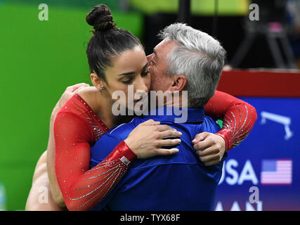 Aly Raisman del Stati Uniti abbracci coach Mihai Brestyan dopo un esame di routine in donne individuale tutto nella ginnastica artistica presso HSBC Arena (Arena Ol'mpica do Rio) presso il Rio 2016 Olimpiadi di estate a Rio de Janeiro, Brasile, il 11 agosto 2016. Foto di Terry Schmitt/UPI Foto Stock