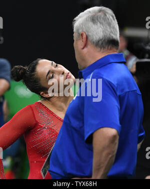 Aly Raisman degli Stati Uniti si estende nei pressi di coach Mihai Brestyan dopo un esame di routine in donne individuale tutto nella ginnastica artistica presso HSBC Arena (Arena Ol'mpica do Rio) presso il Rio 2016 Olimpiadi di estate a Rio de Janeiro, Brasile, il 11 agosto 2016. Foto di Terry Schmitt/UPI Foto Stock