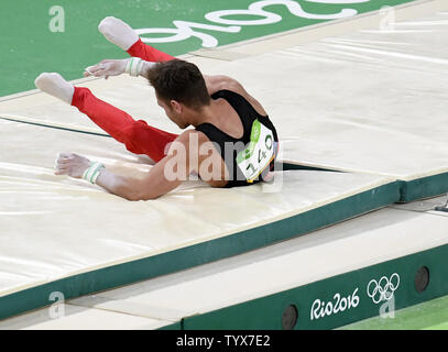 Ginnasta tedesco Andreas Bretscheider cade al tappeto dopo aver perso la sua presa sulla barra orizzontale durante la sua routine negli uomini di ginnastica artistica completa individuali finali del Rio 2016 Olimpiadi di estate a Rio de Janeiro, Brasile, 10 agosto 2016. Il Giappone Kohei Uchimura ha vinto la medaglia d'Oro, la bordatura di fuori dell'Ucraina Oleg Verniaiev, che ha vinto la medaglia d'argento e Gran Bretagna Max Whitlock ha vinto il bronzo. Foto di Mike Theiler/UPI Foto Stock