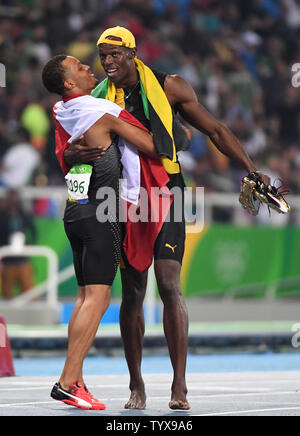 Medaglia d'oro della Giamaica Usain Bolt è abbracciato dalla medaglia di bronzo Andre De Grasse (CAN) dopo aver vinto gli Uomini 100m Finale nello stadio olimpico al Rio 2016 Olimpiadi di estate a Rio de Janeiro, Brasile, il 14 agosto 2016. Foto di Terry Schmitt/UPI Foto Stock