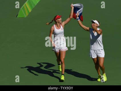 Elena Vesnina, destra e Ekaterina Makarova della Russia celebrare dopo aver sconfitto la Svizzera per vincere la medaglia d'oro nel doppio femminile all'Olympic Tennis Stadium presso il Rio 2016 Olimpiadi di estate a Rio de Janeiro, Brasile, il 14 agosto 2016. Foto di Richard Ellis/UPI.. Foto Stock