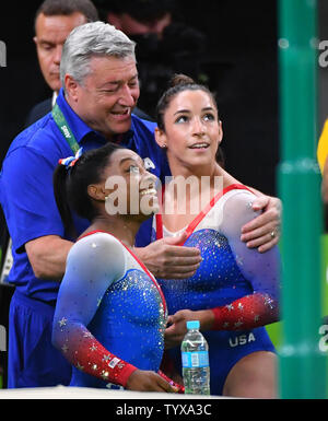 Coach Mihai Brestyan, Aly Raisman e Simone Biles degli Stati Uniti sorriso dopo la loro vittoria di argento e di oro medaglie nel pavimento esercitare all'Olympic Arena del Rio 2016 Olimpiadi di estate a Rio de Janeiro, Brasile, 16 agosto 2016. Foto di Kevin Dietsch/UPI Foto Stock