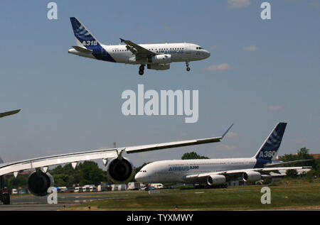 L'Airbus A318 terre come la nuova A380, il più grande aereo di linea di passeggeri, è sulla pista di rullaggio durante la fase di apertura della quarantaseiesima Paris Air Show di Le Bourget, vicino a Parigi, in Francia il 13 giugno 2005. (UPI foto/David Silpa) Foto Stock