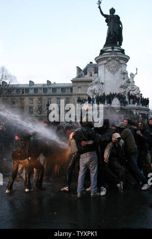 Francese di polizia antisommossa utilizzare acqua cannoni per disperdere i giovani dopo scontri alla fine di uno studente e unione di protestare contro la gioventù del diritto del lavoro primo contratto di lavoro (CPE) a Parigi Martedì 28 marzo, 2006. Più di un milione di manifestanti versata in Francia le strade e i percussori arrestare la Torre Eiffel e interrotto l'aereo, treno e di autobus Martedì in più grandi proteste a livello nazionale finora contro una nuova legge che renderà più facile il fuoco dei giovani. (UPI foto/William Alix) Foto Stock