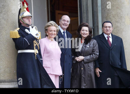 Una Guardia repubblicana sorge presso l'attenzione come il presidente francese Jacques Chirac (C) e sua moglie, Bernadette (2L), posa con il Presidente egiziano Hosni Mubarak (R) e sua moglie, Suzanne (2R), al momento del loro arrivo alla Elysee Palace per il pranzo a Parigi il 8 dicembre 2006. Mubarak e il suo omologo francese in precedenza presentato una mostra di tesori sommersi spanning 1.500 anni di storia egiziana. (UPI foto/Eco Clemente) Foto Stock