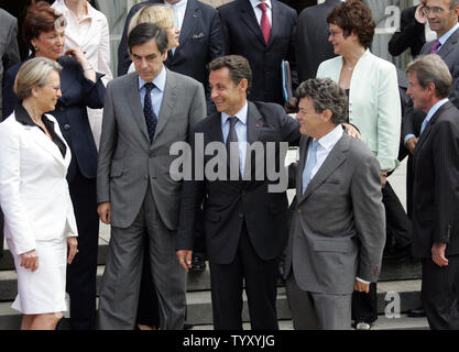 Il Presidente francese Nicolas Sarkozy (anteriore C) tiene appena nominato Ministro dell' ambiente Jean-Louis Borloo come egli chat con il Ministro degli Interni Michele Alliot-Marie (L), della gioventù e dello sport il Ministro Roselyne Bachelot-Narquin superiore (L) e il Premier Francois Fillon (2L) come egli si prepara a posa per una foto di famiglia con i membri del nuovo organo di governo dell'Elysee Palace a Parigi il 20 giugno 2007, dopo la loro prima riunione del gabinetto. Altri sono il ministro degli esteri Bernard Kouchner (R) e Junior il Ministro per l'ambiente Nathalie Kosciusko-Morizet (2R). (UPI foto/Eco Clemente) Foto Stock