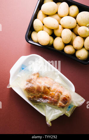 Roastbeef grezzi preparati a base di carne, caparisoned con omento di maiale grasso e rosmarino all'interno di un sous vide borsa pronto per essere cotto con un rooner con patate piccole, Foto Stock