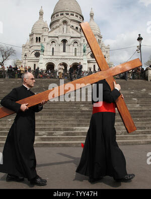 Arcivescovo di Parigi Monseigneur André Vingt-Trois (R) porta una croce presso la Basilica del Sacre Coeur durante il 'Station della croce' Buon Venerdì rituale e nella zona di Montmartre di Parigi il 10 aprile 2009. Il rituale che simbolicamente rappresenta le ultime ore della vita di Gesù Cristo. (UPI Photo/ David Silpa) Foto Stock