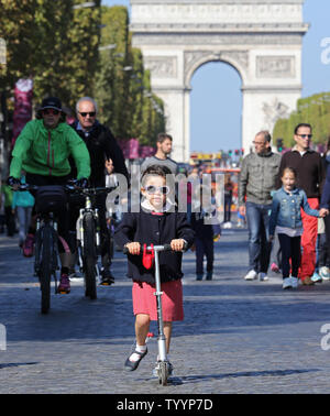 Una ragazza cavalca il suo scooter lungo la Avenue des Champs-Elysees durante il 'Day senza automobili' a Parigi il 27 settembre 2015. La manifestazione, prevista in concomitanza con il vertice mondiale sul cambiamento climatico entro la fine di quest'anno, ha evidenziato la necessità di disporre di capitali europee per ridurre l'inquinamento atmosferico. Foto di David Silpa/UPI Foto Stock