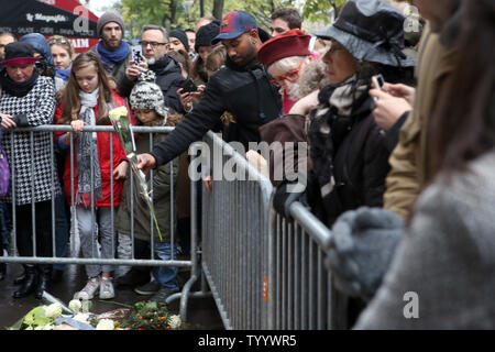 La gente paga un tributo alle vittime di un attacco terroristico nella parte anteriore del Bataclan Concert Hall di Parigi, Francia, il 13 Nov 2016, segnando un anniversario di una serie di attentati mortali. Alcuni 130 sono stati uccisi, 90 di loro a Bataclan, quando militanti islamici è andato del rampage nel cuore della capitale francese. Foto di Maya Vidon-White/UPI Foto Stock