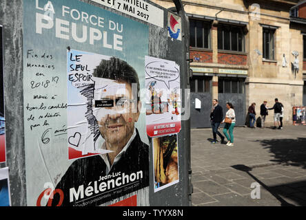 Residenti a piedi passato poster della campagna di estrema sinistra elezioni presidenziali contender Jean-Luc Melenchon a Parigi il 23 aprile, 2017. Il voto è in corso nel primo round di un imprevedibile elezioni presidenziali il cui esito potrebbe rivelarsi cruciale per il futuro di un profondamente diviso il paese e un nervoso Unione europea. Foto di Maya Vidon-White/UPI Foto Stock