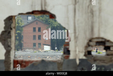 Il cinese a piedi attraverso un recentemente demolito quartiere nel centro di Pechino, 23 maggio 2006. Il tutto per tutto in Pechino case a cortile tradizionali vengono abbattute dagli equipaggi di demolizione, nonostante le prove della loro importanza storica. Con un vero boom immobiliare acquistando slancio e le olimpiadi del 2008 si avvicina, Pechino è rapidamente abbattendo la sua famosa hutong, stretti vicoli pieni di case a cortile che sono 100 400 anni. (UPI foto/Stephen rasoio) Foto Stock