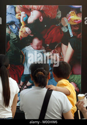 Il cinese guarda a un nuovo, mostra all'aperto di terremoto fotografie in centro a Pechino il 24 maggio 2008. Gli operatori di soccorso in Cina continuano a liberare i superstiti dal paese i peggiori quake in decenni. (UPI foto/Stephen rasoio) Foto Stock