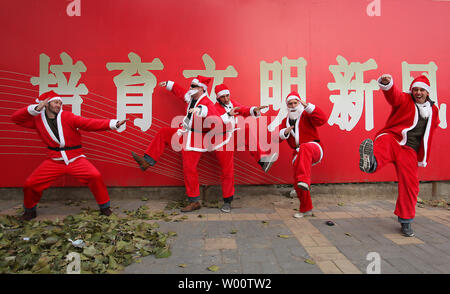 Gli stranieri vestito di Babbo Natale costumi strike kong fu pone su un marciapiede come fanno il loro modo di piazza Tiananmen per SantaCon, un annuale "Santa Claus convenzione celebrando allegria, la buona volontà e il divertimento,' a Pechino dicembre111, 2010. Polizia in piazza Tiananmen, sorpresi dal grande raduno di persone che indossano il rosso, ordinato al gruppo di disperdere e lasciare la piazza mentre molesto anche i giornalisti stranieri, per trattenere uno. Piazza Tiananmen era sotto strette misure di sicurezza come il Premio Nobel per la pace si è tenuta la cerimonia in Norvegia. UPI/Stephen rasoio Foto Stock
