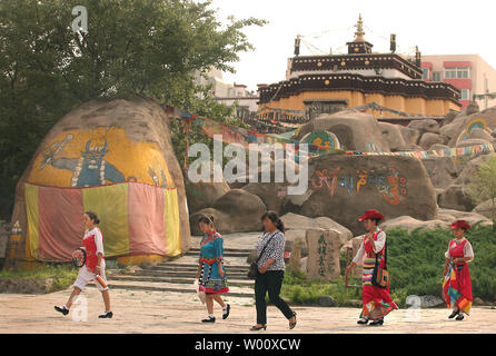 Artisti cinesi a piedi passato un su piccola scala versione del Tibet il Potala Palace si trova a Pechino la minoranza etnica Park il 25 giugno 2011. La Cina ha chiuso il Tibet a tutti i turisti stranieri fino alla fine del mese di luglio, nel muoversi che è visto come un tentativo da parte di Pechino per evitare disordini in anticipo delle celebrazioni per i 90 anni dalla fondazione della sentenza del Partito comunista. UPI/Stephen rasoio Foto Stock