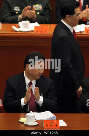 Futuro leader della Cina Xi Jinping applaude mentre il segretario generale del Comitato Centrale del Partito comunista e il presidente cinese Hu Jintao (fondo) passeggiate passato lui dopo la consegna l'apertura del rapporto di lavoro durante la cerimonia di apertura del diciottesimo congresso del partito comunista nella Grande Sala del Popolo di Pechino il 8 novembre 2012. I delegati del partito comunista sono arrivate in Cina il capitale per la riunione che inizia una volta che-in-un-decade il trasferimento di potenza. Il presidente Hu Jintao passerà la leadership a Xi Jinping. UPI/Stephen rasoio Foto Stock