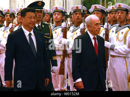 Il presidente israeliano Shimon Peres (R) e il presidente cinese Xi Jinping frequentare un militare di guardia d'onore la cerimonia di benvenuto nella Grande Sala del popolo a Pechino il 8 aprile 2014. UPI/Stephen rasoio Foto Stock