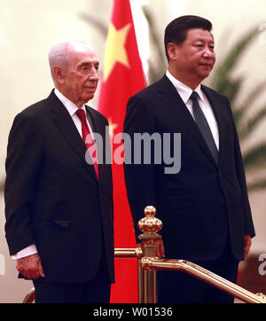 Il presidente israeliano Shimon Peres (L) e il presidente cinese Xi Jinping frequentare un militare di guardia d'onore la cerimonia di benvenuto nella Grande Sala del popolo a Pechino il 8 aprile 2014. UPI/Stephen rasoio Foto Stock