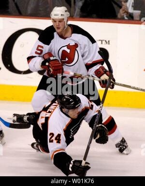 I volantini' Sami Kapanen (24) viene sconvolto quando il taglio davanti ai demoni' Colin bianco (5) come host di Philadelphia e New Jersey nel primo gioco della Eastern Conference Quarti di Finale presso il Wachovia Center di Philadelphia, l'8 aprile 2004. (JON ADAMS/UPI) Foto Stock