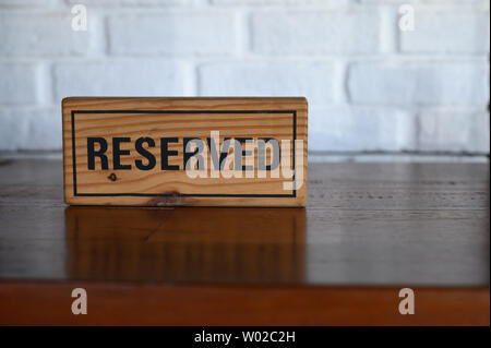 Ristorante riservato tabella segno tavolo riservato. Un cartellino di prenotazione posto sulla tavola di legno Foto Stock