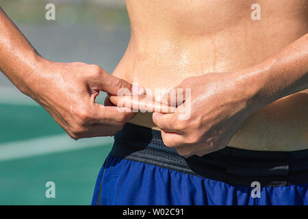 Man mano la pelle di presa di grasso in eccesso alla cintura Foto Stock