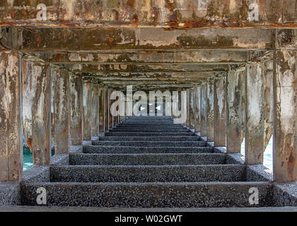 Calcestruzzo Strutturale di pilastri e di travi sotto il ponte è stato danneggiato in mare. Foto Stock