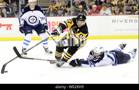 Getti di Winnipeg centro Adam Lowry (17) rompe il colpo di Pittsburgh Penguins center Sidney Crosby (87) nel secondo periodo contro il Winnipeg getti alla PPG vernici Arena di Pittsburgh il 16 febbraio 2017. Foto di Archie Carpenter/UPI Foto Stock