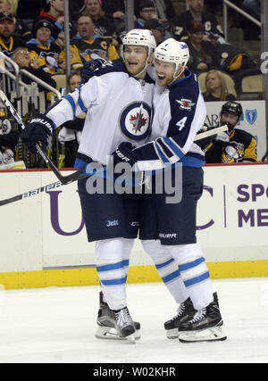 Getti di Winnipeg defenceman Paul Postma (4) e getti di Winnipeg centro Adam Lowry (17) celebra il traguardo nel terzo periodo dei pinguini 4-3 ore di straordinario vincere contro i getti di Winnipeg al PPG vernici Arena di Pittsburgh il 16 febbraio 2017. Foto di Archie Carpenter/UPI Foto Stock