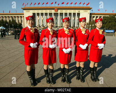 Delegato cinese hostess posano per una foto onTiananmen piazza durante la cerimonia di apertura del XVII congresso di partito presso la Grande Sala del Popolo (fondo) a Pechino il 15 ottobre 2007. L'elite della Cina del Partito comunista ha aperto loro quinquennale congresso, un evento ampiamente previsto per vedere il presidente Hu Jintao ha approvato come la nazione leader per altri cinque anni. (UPI foto/Stephen rasoio) Foto Stock