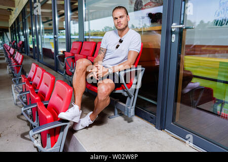 Di Sandhausen, Germania. Il 25 giugno, 2019. Rurik Gislason, giocatore di seconda divisione football team SV Sandhausen, siede sulla tribuna dello stadio. Gislason da SV Sandhausen divenne famosa in tutto il mondo un anno fa. Non perché egli ha consegnato sensazionali performances per Islanda presso la Coppa del Mondo in Russia, ma a causa del suo aspetto. (A dpa " Un anno dopo il hype: la vita nuova del 'bello' Rurik Gislason') Credito: Uwe Anspach/dpa/Alamy Live News Foto Stock