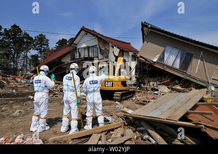 Polizia giapponese chimici indossare tute di protezione ricerca di vittime all'interno della 20 km di raggio attorno a Fukushima Dai-ichi centrale nucleare a Minamisoma, Fukushima prefettura, Giappone, il 15 aprile 2011. Un terremoto e dal conseguente tsunami del marzo 11 case distrutte, ha provocato migliaia di vittime e causato una catastrofe nucleare. UPI/Keizo Mori Foto Stock