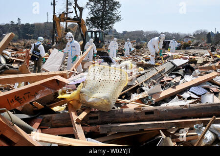 Polizia giapponese chimici indossare tute di protezione ricerca di vittime all'interno della 20 km di raggio attorno a Fukushima Dai-ichi centrale nucleare a Minamisoma, Fukushima prefettura, Giappone, il 15 aprile 2011. Un terremoto e dal conseguente tsunami del marzo 11 case distrutte, ha provocato migliaia di vittime e causato una catastrofe nucleare. UPI/Keizo Mori Foto Stock