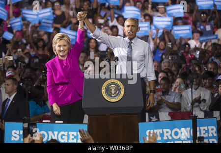 Il presidente Barack Obama e il candidato presidenziale democratico Hillary Clinton tenere le mani dopo aver premuto un evento di campagna a Charlotte, Carolina del Nord il 5 luglio 2016. Questo è il primo evento che il Presidente Obama ha lottato con Clinton. Foto di Kevin Dietsch/UPI Foto Stock