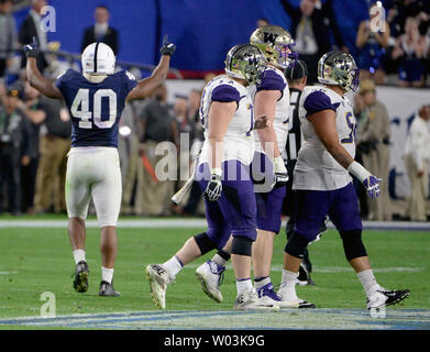 La Penn State Nittany Lions' Jason Cabinda (L) alza le mani nella celebrazione come Washington Huskies' giocatori offensivi testa a margine dopo il guasto di un quarto down play messo fuori gioco per la Nittany Lions nel quarto trimestre della Play Station Fiesta Bowl presso la University of Phoenix Stadium di Glendale, Arizona Dicembre 30, 2017. La Nittany Lions sconfitto il Huskies 35-28. Foto di arte Foxall/UPI Foto Stock