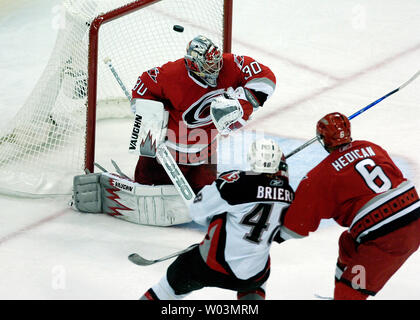 Buffalo Sabres' Daniel Briere, anteriore sinistra, spara il puck oltre la spalla di Carolina Hurricanes goaltender Cam Ward durante il gioco 1 del NHL Eastern Conference finali all'RBC Center in Raleigh, NC 20 maggio 2006. La difesa sul gioco è Carolina Hurricanes' il Bret Hedican, anteriore destra. (UPI foto/Jeffrey A. Camarati) Foto Stock