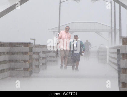 I pescatori Alan Roberts (L) e Destin Tiburcio, 7 anni, la lotta contro il vento e le piogge dalla tempesta tropicale Isacco sul molo la zavorra Point Park a Tampa, Florida 27 agosto 2012 tempesta tropicale Isaac ha causato la cancellazione della Convention Nazionale Repubblicana per il giorno. UPI/Mark Wallheiser Foto Stock