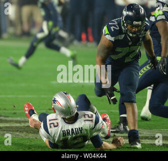 Seattle Seahawks Michael Bennett (72) appiattisce New England Patriots QB Tom Brady (12) dopo un passaggio nel terzo trimestre del Super Bowl XLIX presso la University of Phoenix Stadium di Glendale, Arizona, 1 febbraio 2015. Foto di Pat Benic/UPI Foto Stock